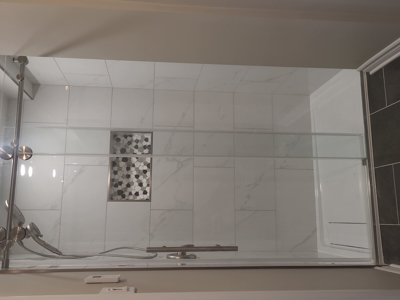 Glass-enclosed shower with custom tile surround