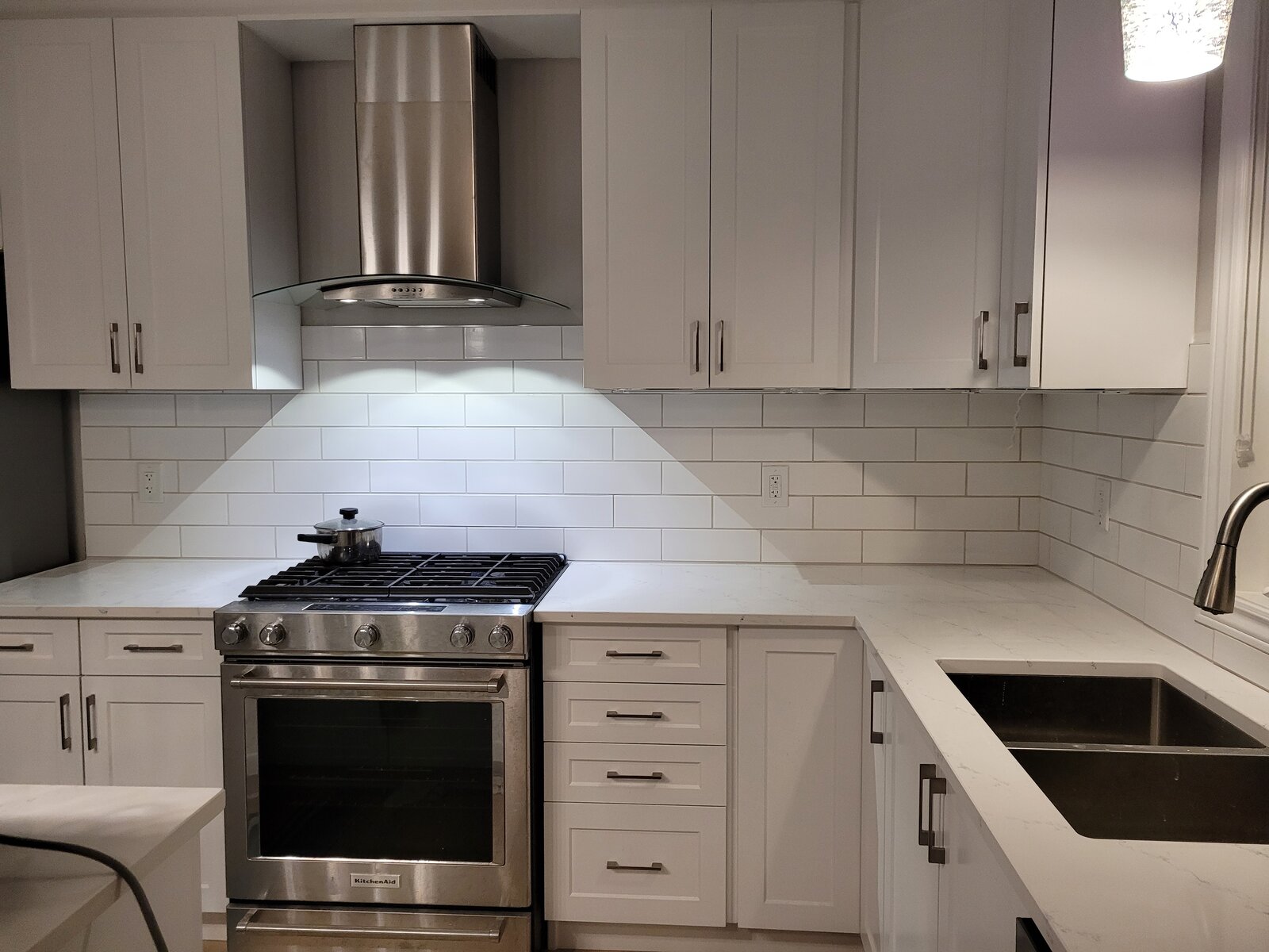 Completed kitchen with stainless steel appliances and ceramic tile backsplash